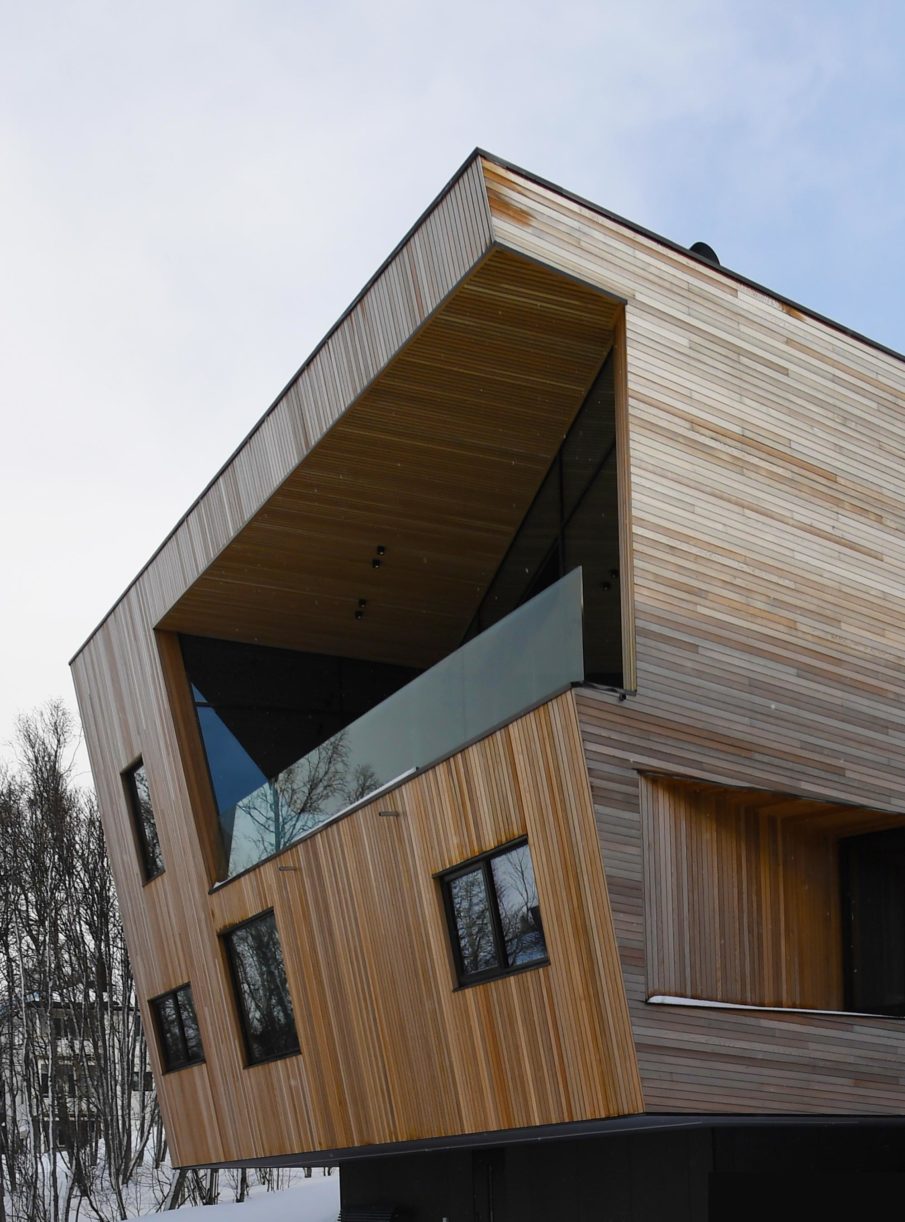 One side of a building with a spacious terrace and an angled wall.