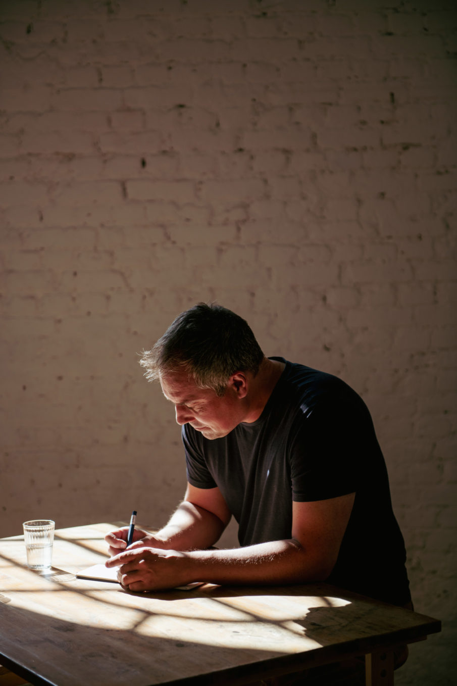 A man sitting at a desk and writing.