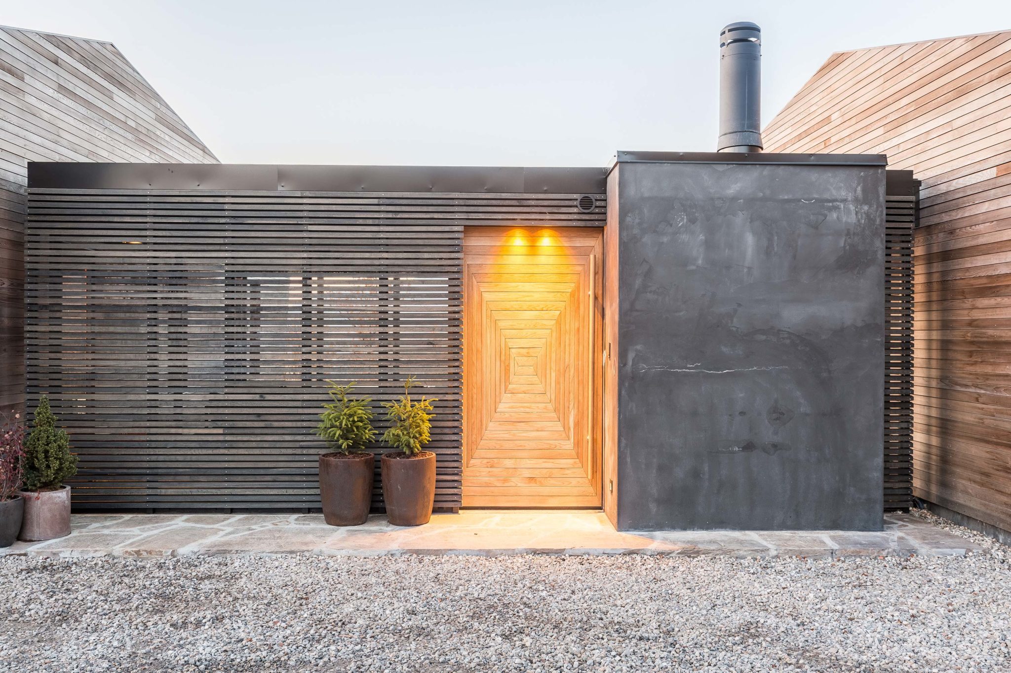 An entrance to a dark building with plants outside.