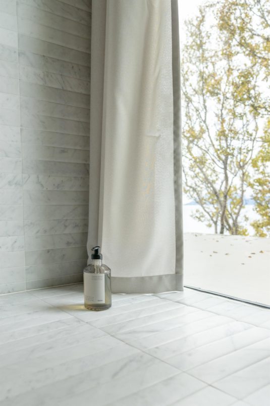 A bar of soap placed on the floor in a shower.