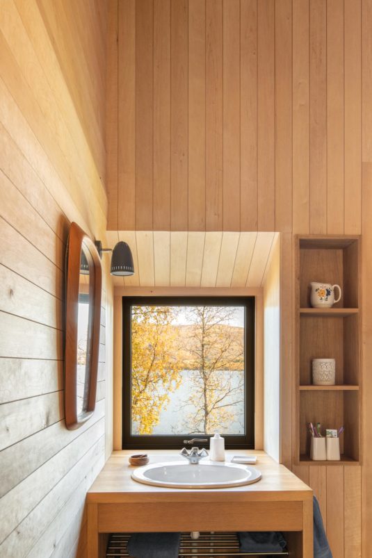 Sink in a bathroom with a window overlooking nature.