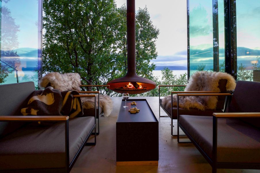 Living room with four chairs, a table, and a modern fireplace.