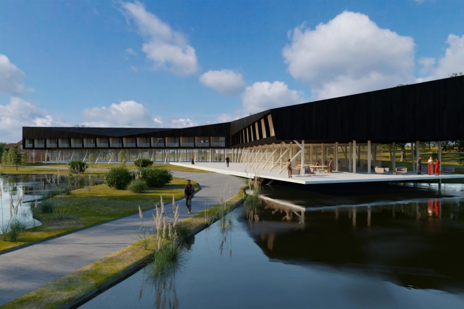 A small pathway surrounded by water leading up to a large black building.